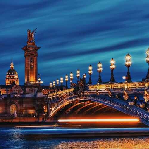 Paris 48 Hours Guide – Night view of Pont Alexandre III bridge glowing with golden lights over the Seine.