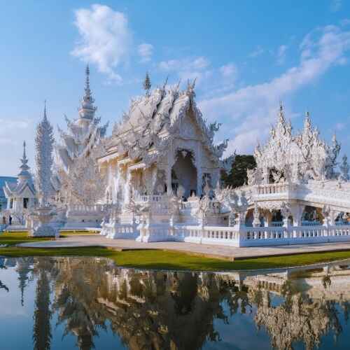 Stunning White Temple Wat Rong Khun in Chiang Rai Thailand reflected in water – featured in Chiang Mai Digital Nomad Guide