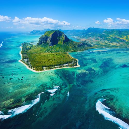 Aerial view of Le Morne and the Mauritius underwater waterfall illusion with dramatic turquoise and deep blue ocean colors.