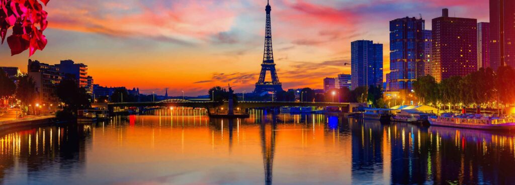 Paris 48 Hours Guide – breathtaking sunset view of the Eiffel Tower reflecting over the Seine River surrounded by city lights and vibrant evening skyline.