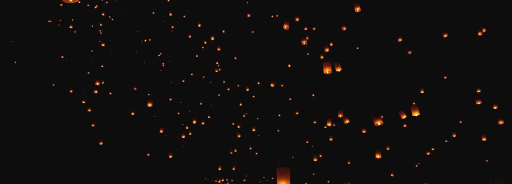 Sky lanterns floating into the night sky during a festival in Thailand, captured for the Chiang Mai Digital Nomad Guide.
