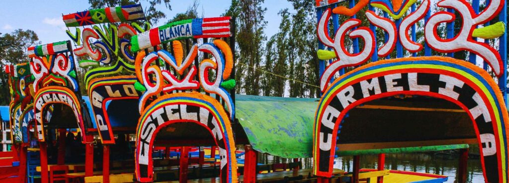 Colorful traditional trajineras boats at Xochimilco in Mexico City, a vibrant cultural attraction featured in the Remote Workers City Guide.